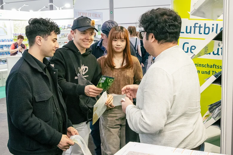 Sagnik Mukherjee vom GeoSN im Gespräch mit zwei interessierten Messebesuchern
