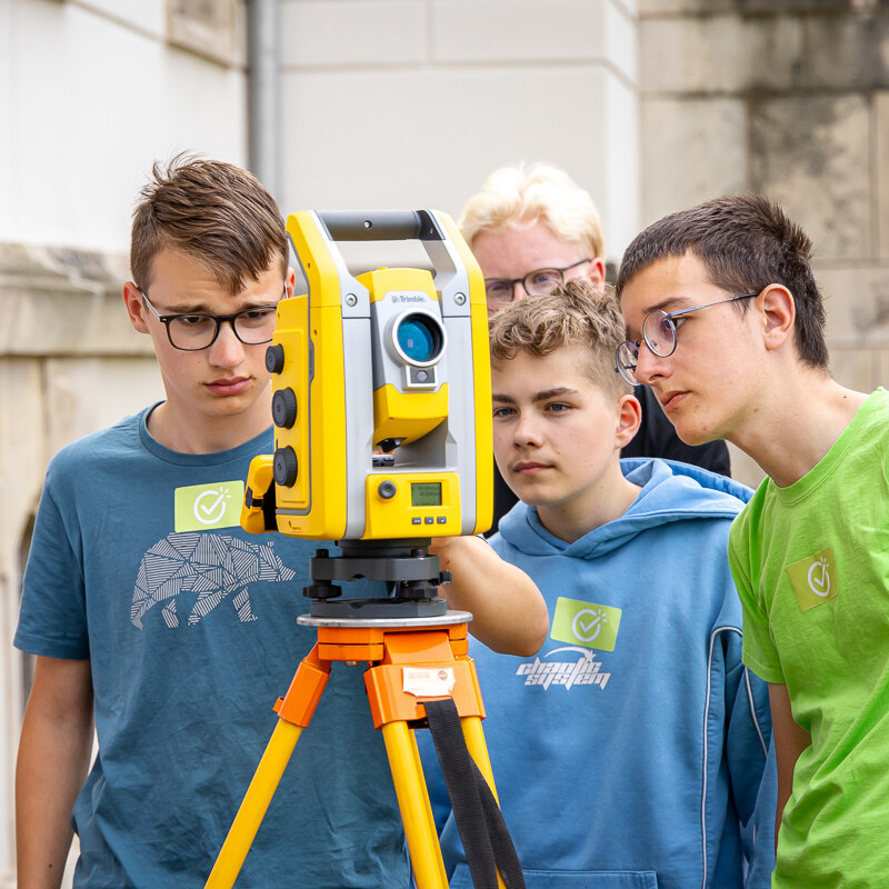 Schülergruppe bei einer Geodäsie-Parcour-Station